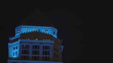 Tarihi eski tarz adliye binasının tepesi gece vakti neon mavisi ile aydınlatılıyor.