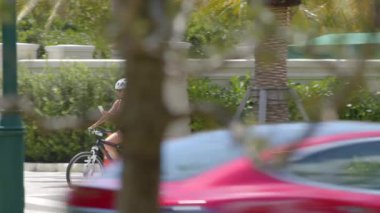 Motosiklet sürerken telefonunu kontrol eden bir kadın.