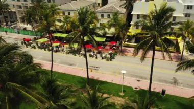 Miami Beach Ocean Drive restoranları Coronavirus Covid 19 hava aracı videosunun pratik sosyal mesafesi için masaları dağıtıyor.