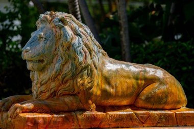 Açık havada güneşle aydınlatılan boyalı aslan heykeli