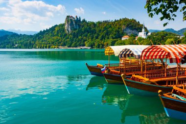Bled Castle cliff arka, Üst Carniola, Slovenya Lake Bled yeşil sularında geleneksel pletna tekneler