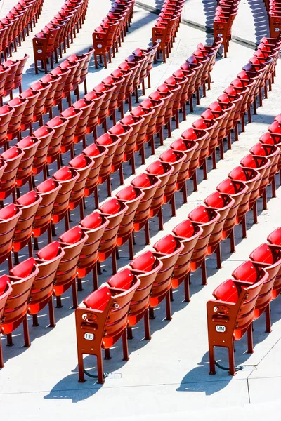Αριθμημένες Σειρές Από Κόκκινα Πλαστικά Καθίσματα Πάνω Από Λευκό Σκυρόδεμα — Φωτογραφία Αρχείου