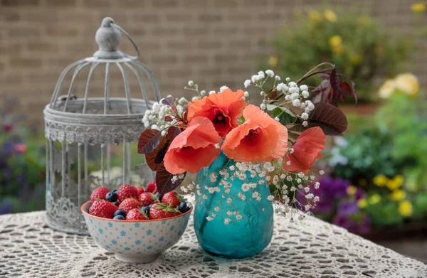 Flowers and berries on the table, outdoor table decor, in the garden
