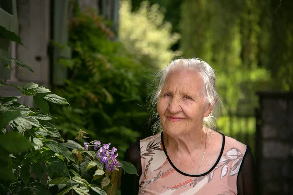Donna anziana con fiori — Foto Stock