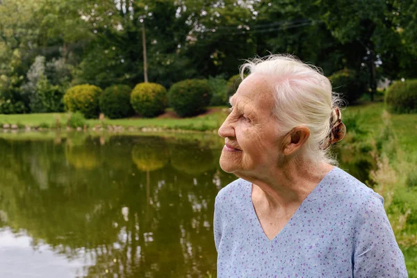 Äldre kvinna utomhus porträtt — Stockfoto