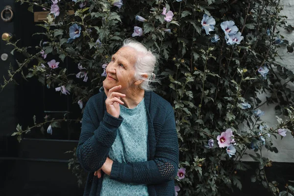 Porträtt Lycklig Äldre Kvinna Utanför Blomma Bakgrond Nära Huset — Stockfoto