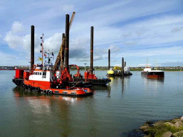 Port Construction Project vessels engaged in harbour reclamation work.