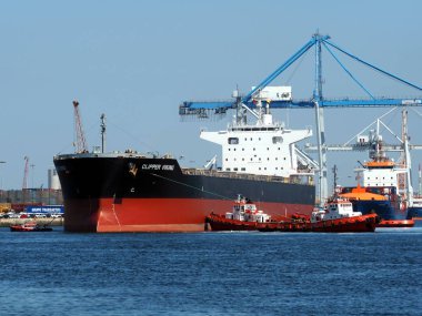 Setubal, Portugal, 10th May 2018. Bulk cargo ship maneuvers at port facilities. clipart