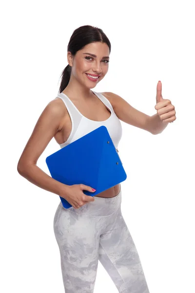 Vista Lateral Hermosa Mujer Fitness Con Portapapeles Azul Haciendo Pulgares — Foto de Stock