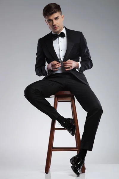 Seductive Businessman Sitting Wooden Chair Buttoning His Black Suit Jacket — Stock Photo, Image