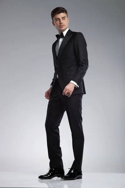 Elegant Young Man Black Tuxedo Standing Light Grey Background Looking — Stock Photo, Image