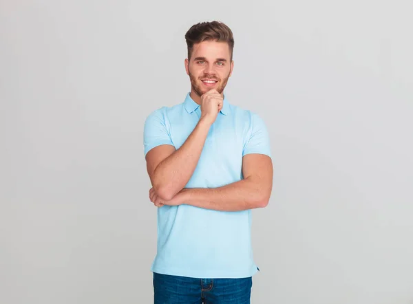 Joven Sonriente Con Una Camiseta Polo Azul Claro Pensando Mientras — Foto de Stock