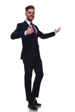 sunulması ve beyaz arka plan üzerinde duran ok işareti yapma Lacivert takım elbiseli mutlu işadamı