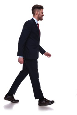 Beyaz arka plan üzerinde yürüme gülümseyen zarif işadamı yan görünüm