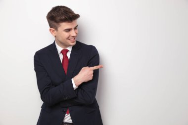 Donanma takım puan parmak ve görünüyor yana açık gri renkli, portre resim üzerinde duran genç işadamı