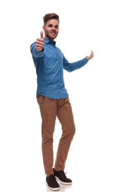 yakışıklı casual adam ok işareti yapar ve beyaz arka plan, tam uzunlukta resim üzerinde dururken arkasında sunar