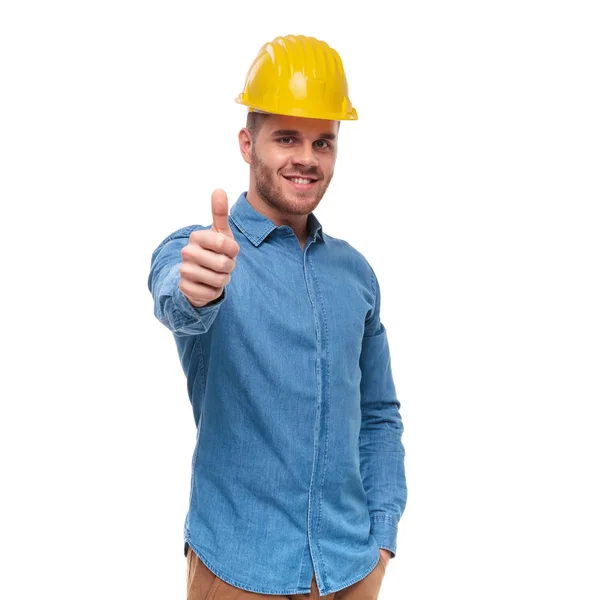 Relaxed Casual Engineer Protection Helmet Makes Thumbs Sign While Standing Royalty Free Stock Photos