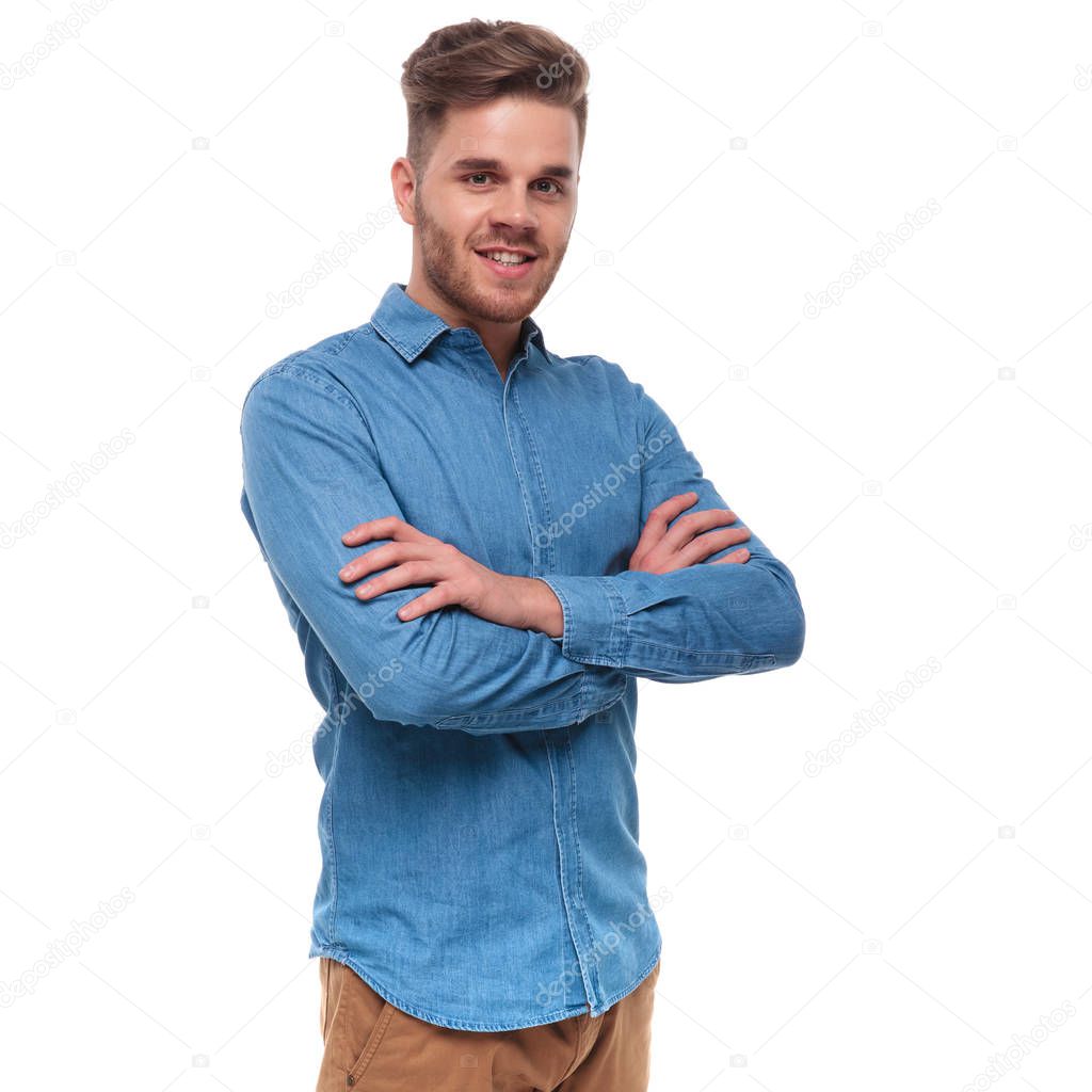 portrait of confident casual man wearing a blue shirt standing on white background with hands folded