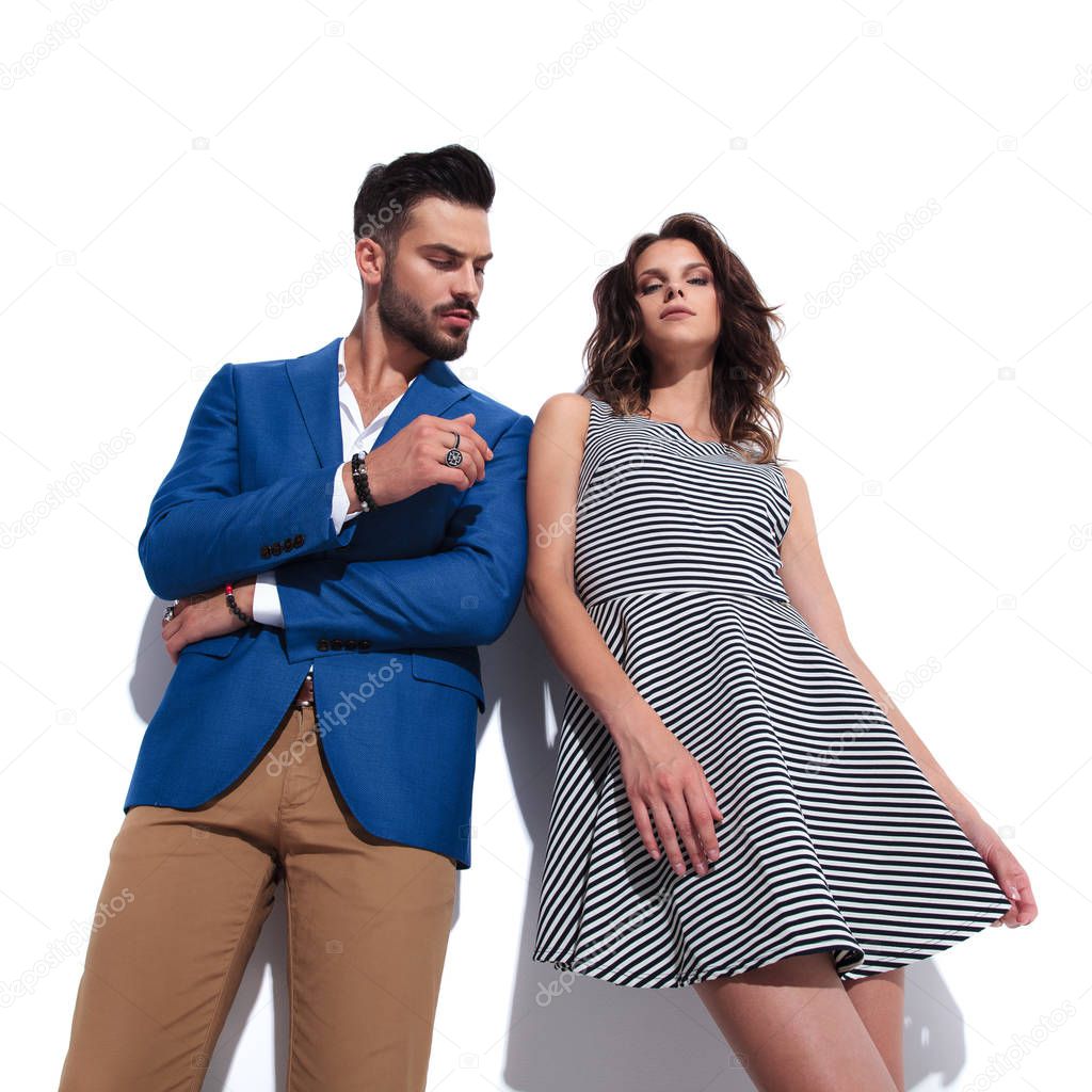 casual woman standing near her man on white background and leaning on him, bottom angle picture