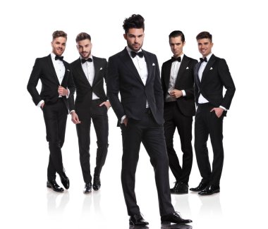 Beyaz arka plan üzerinde ceplerinde beş yakışıklı mamülleri rahat lider konumu ile önlerinde olan grup eller