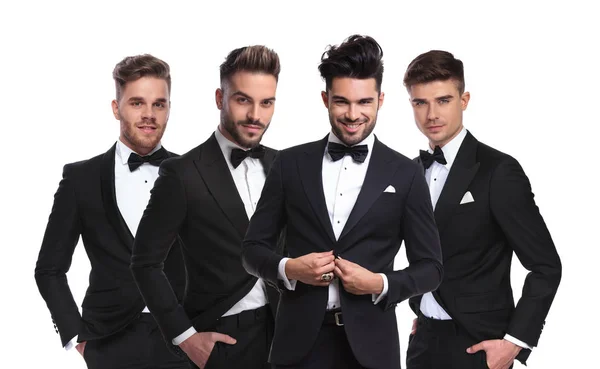 Four Young Men Black Tuxedoes Standing Together White Background Hands — Stock Photo, Image