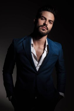 ceplerinde siyah arka plan, portre resim üzerine yakışıklı akıllı casual adam mavi takım elbise ve geri alınan forması ile ayakta eller