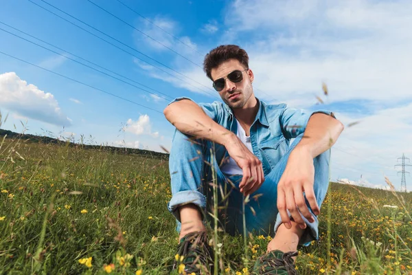 田舎で芝生で休んで眼鏡の魅力的なカジュアルな男 — ストック写真
