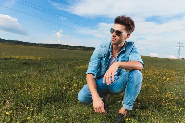 Casual Man Wearing Sunglasses Undone Blue Shirt Kneeling Hill Looking — Stock Photo, Image