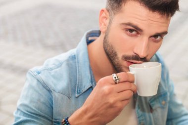 şehirde bir kafe dükkanda kahve dışında içme mavi bir gömlek giymiş yakışıklı casual adam