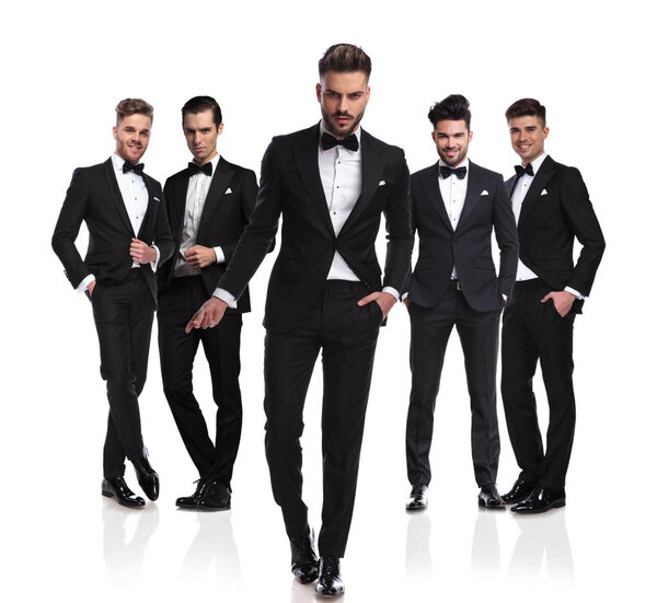 sexy groom leader walking in front of his group and snapping fingers, on white background