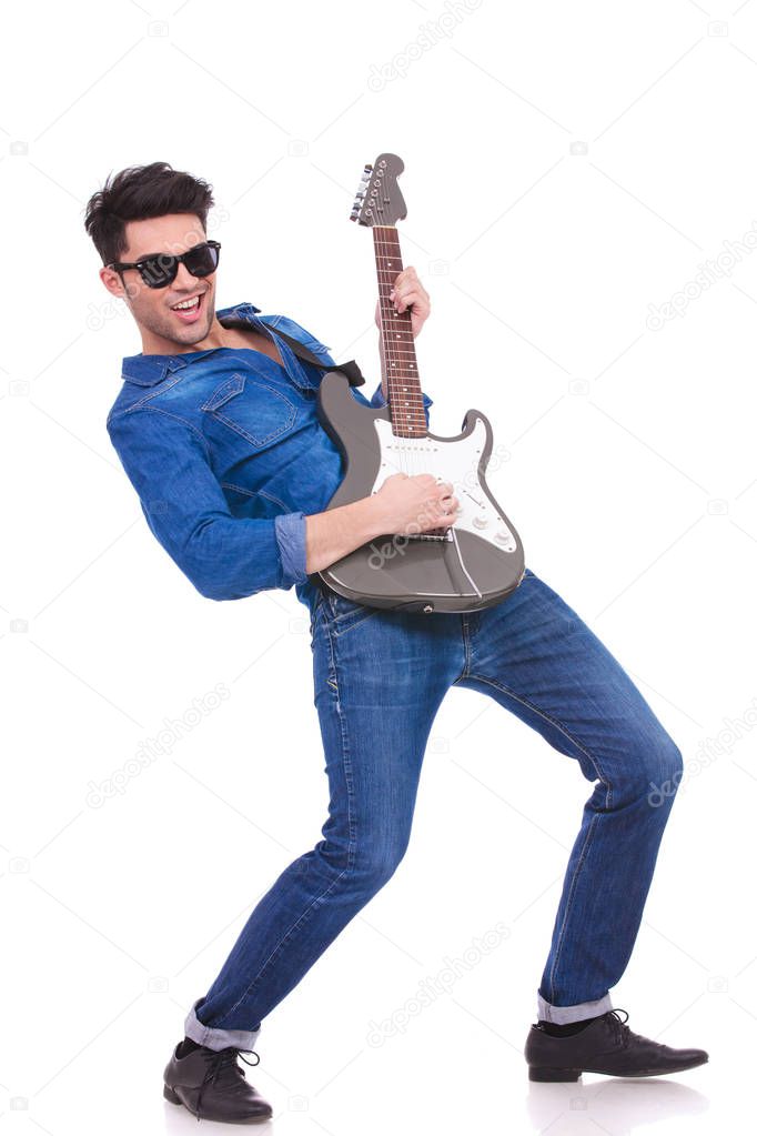 young cool guitarist playing his electric guitar on white background