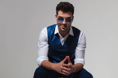 gülümseyen ve avuç içi ile birlikte açık gri renkli, portre resim üzerinde oturan zarif adam