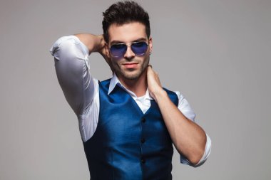 boynunu ışık gri arka plan üzerinde tutarak poz gözlüklü zarif adam portresi