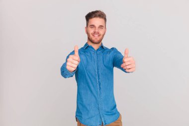 ışık gri arka plan üzerinde duran ok işareti yapma sevinçli casual adam portresi