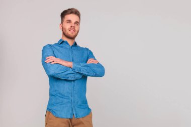 yan elleri ile ışık gri arka plan üzerinde dururken isteyen emin casual adam portresi katlanmış