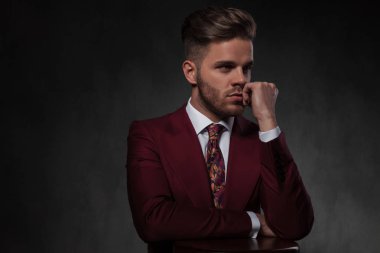 elleri üzerinde ahşap sandalye dinlenme ve yan gri duvar kağıdı arka plan üzerinde dururken isteyen düşünceli zarif adam portresi