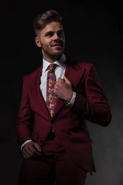 Retrato Hombre Sonriente Organizando Collar Traje Grena Mirando Lado Mientras — Foto de Stock