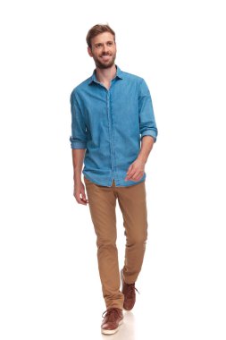 yürüyüş ve beyaz arka plan üzerinde tarafına bakarak gülümseyen genç casual adam