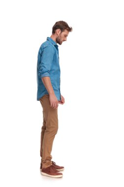 casual adam beyaz backgrouond üzerinde bir şey arayan bir yan görünüm