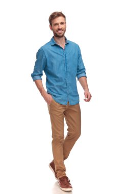 mutlu genç casual adam cebinde el ile beyaz arka plan üzerinde yürüme