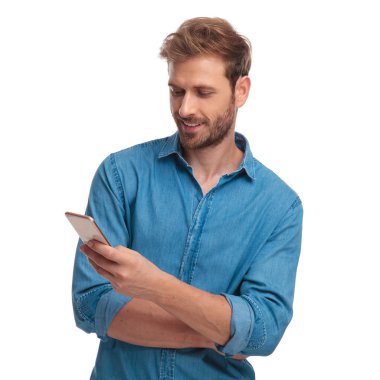 Genç mutlu casual adam beyaz zemin üzerine cep telefonuna sms mesajı okur