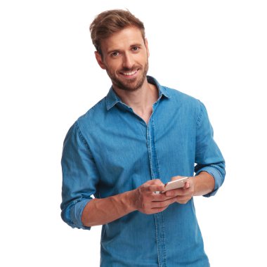 Casual adam manifatura onun cep telefonu beyaz arka plan üzerinde gülümseyen