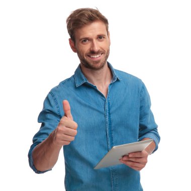casual adam tablet üzerinde çalışan gülümseyen beyaz arka plan üzerinde ok işareti yapar