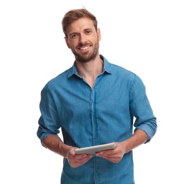 bir tablet pad bilgisayar beyaz arka plan üzerinde tutan genç casual adam gülümseyen