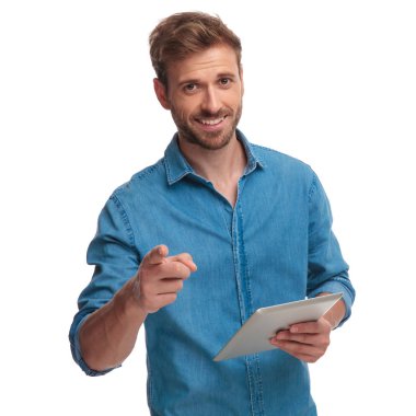 Beyaz arka plan üzerinde tablet tutarken gülümseyen öğrenci işaret parmağı