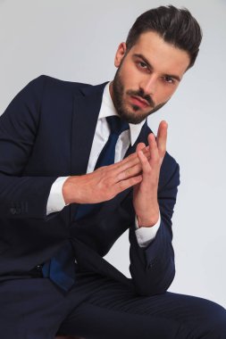 avuç içi açık gri renkli, portre resim üzerinde otururken bir arada tutan Lacivert takım elbiseli çekici iş adamı