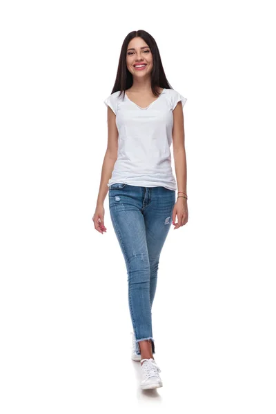 Gioiosa Donna Casual Indossando Jeans Camminare Sfondo Bianco Mentre Sorride — Foto Stock