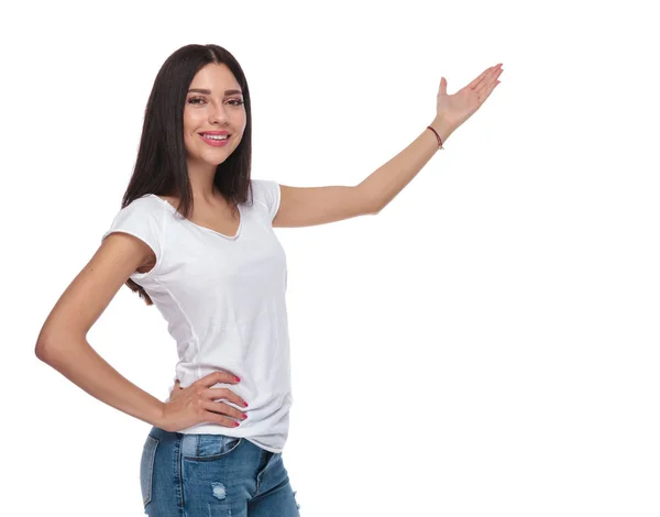 Ładna Brunetka Dziewczyna Ubrana Biały Shirt Dżinsy Uśmiechając Się Prezentowania — Zdjęcie stockowe