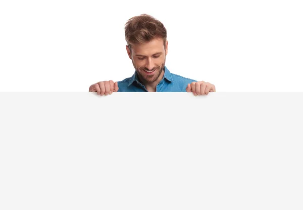 Sonriente Hombre Casual Sosteniendo Tablero Blanco Mira Hacia Abajo Fondo — Foto de Stock