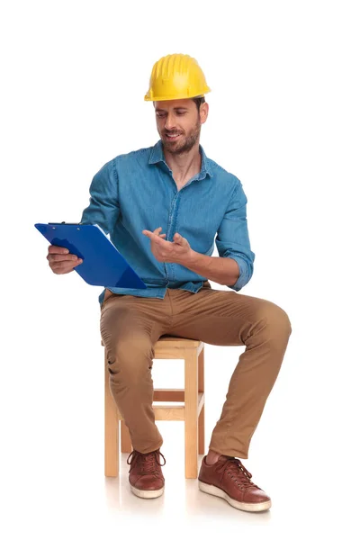 Young Seated Construction Engineer Pointing His Clipboard White Background — Stock Photo, Image